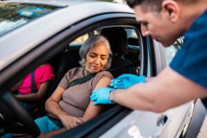 Senior Woman Being Vaccinated Inside Car