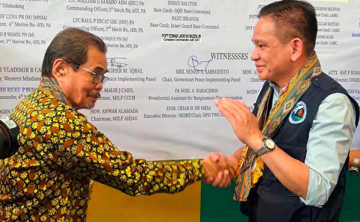Government Peace Implementing Panel (PIP) and Peace Sec. Mel Senen Sarmiento (right) and MILF-PIP chair Mohagher Iqbal shake hands after the signing of the MOA related to the BARMM elections. The signing was held at MILF’s Camp Darapanan in Sultan Kudarat, Maguindanao del Norte on Monday, Aug. 31. Photo by OPAPRU