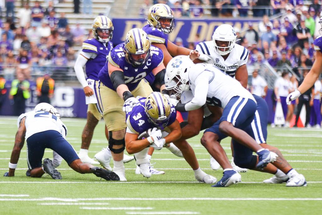 Brian Bonner Jr. (34) of the Washington Huskies fights for yards as UW escapes Utah State 16-14 on Saturday, Sept 12, 2026 at Husky Stadium in Seattle, Washington. (Photo courtesy of Mason Coe)