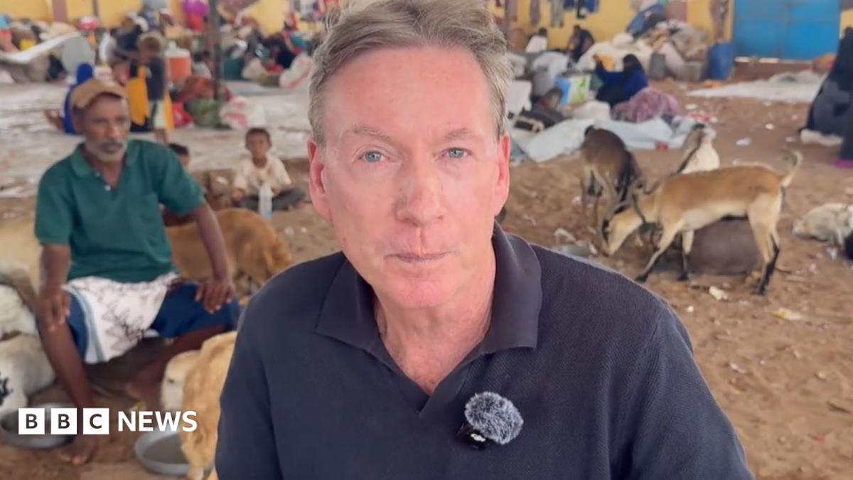 Frank Gardner in a blue short with refugees behind him