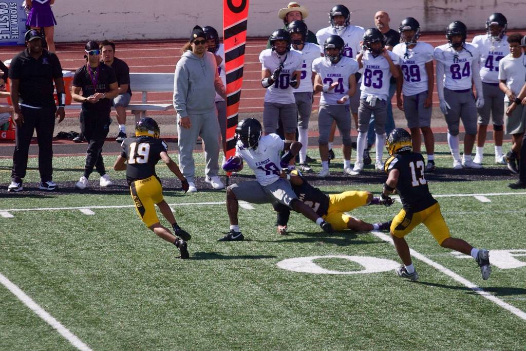 Lincoln senior Gesiah Joseph (2 in black) pulls down Kamiak senior Don Dankyi (18) during the Abes’ 47-6 win over the Knights at the Lincoln Bowl on Sept. 5, 2026. (Joe Pohoryles / The Herald)