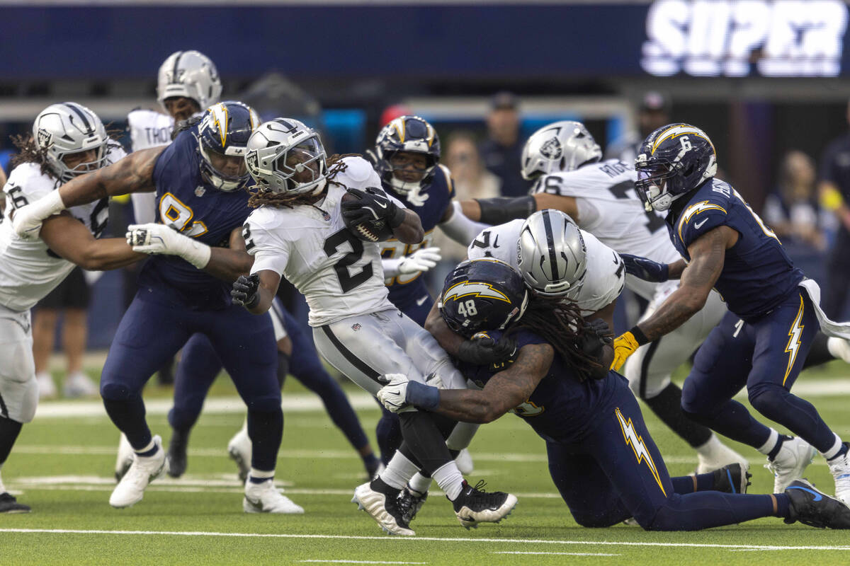 Raiders running back Ashton Jeanty (2) is tackled by Los Angeles Chargers outside linebacker Bu ...