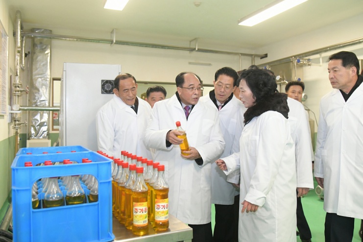 Officials inspect cooking oil bottles at a newly completed local industry factory in Kyongsong county, North Hamgyong province, North Korea