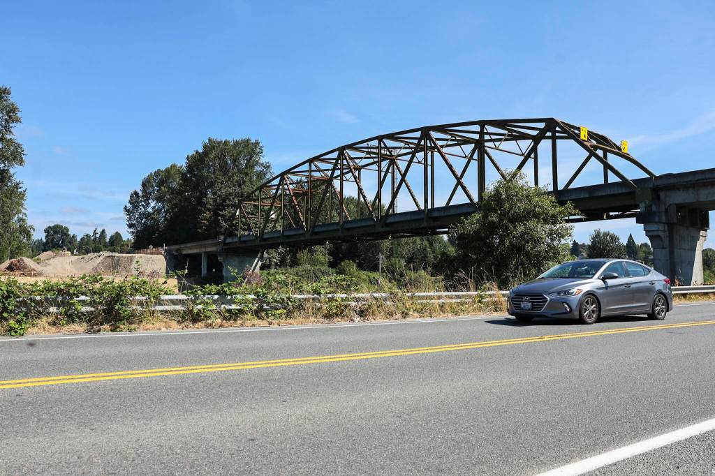A car drives along Lowell-Snohomish River Road passing underneath Highway 9 on Monday, Aug. 10, 2026 in Snohomish, Washington. (Olivia Vanni / The Herald)