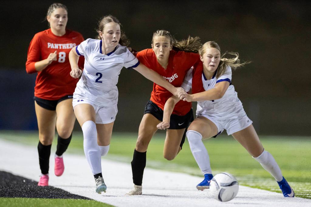Kamiak’s Elle Johnson and Finley LaCoss defend against Snohomish’s Jenna Pahre as she runs after the ball during the game on Tuesday, Sept. 1, 2026 in Snohomish, Washington. (Olivia Vanni / The Herald)