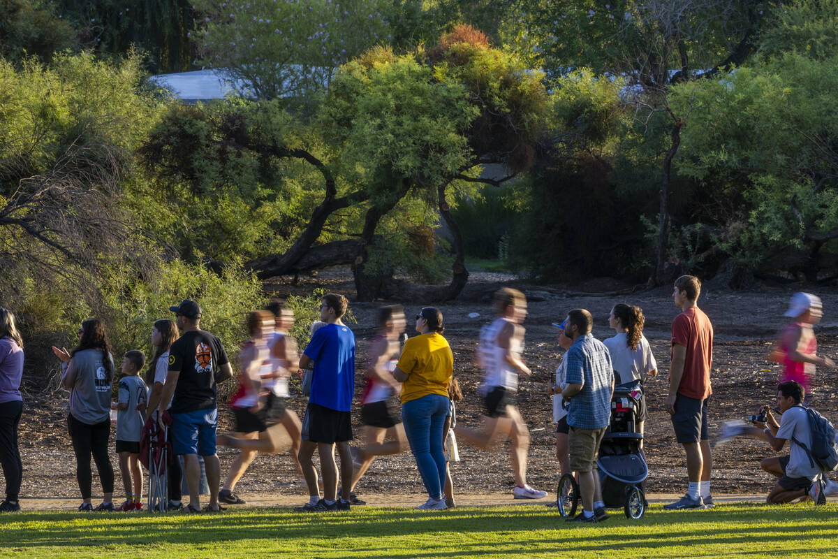 The crowd lines the course in supports as the Varsity A Boys competitors stream by during the 5 ...