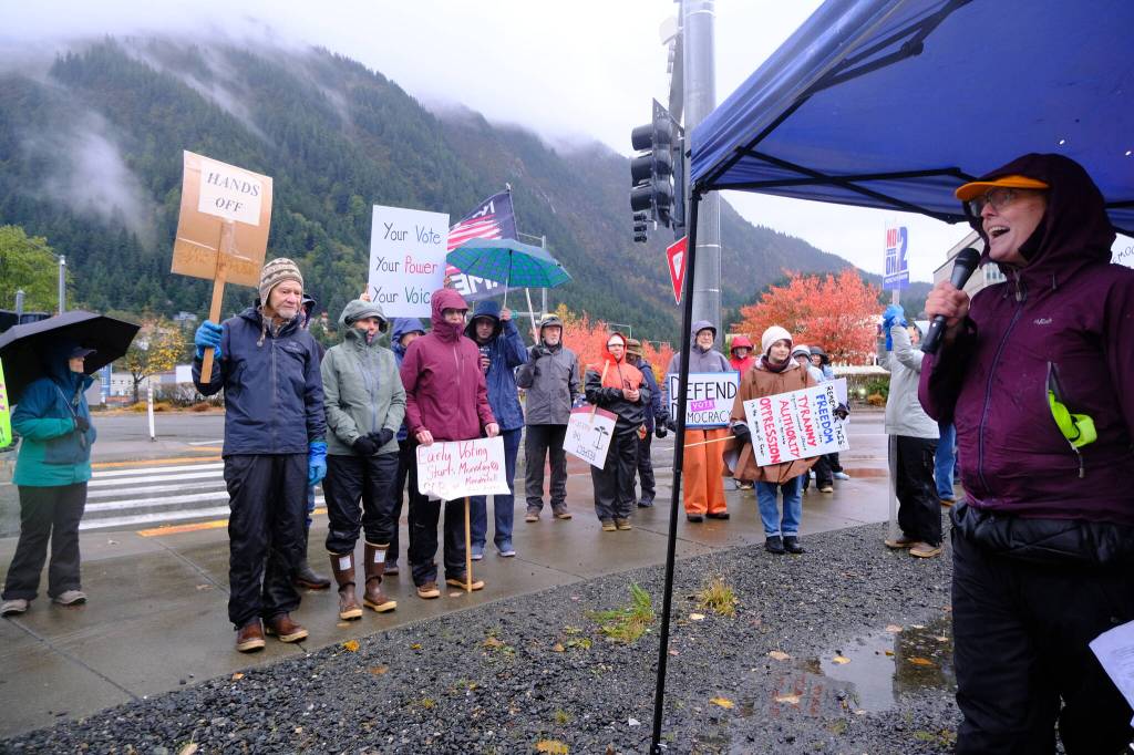 Anjuli Grantham, an organizer with Juneau for Democracy, speaks to a crowd gathered for a nationwide No Kings day of action on Oct. 17, 2026 and urges Alaskans to vote early. (Photo by Corinne Smith/Alaska Beacon)