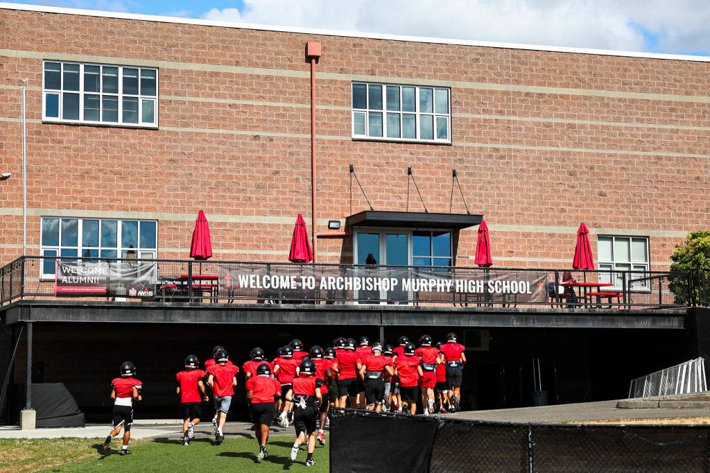 Archbishop Murphy football players run into the locker room during practice on Thursday, Aug. 27, 2026 in Everett, Washington. (Olivia Vanni / The Herald)
