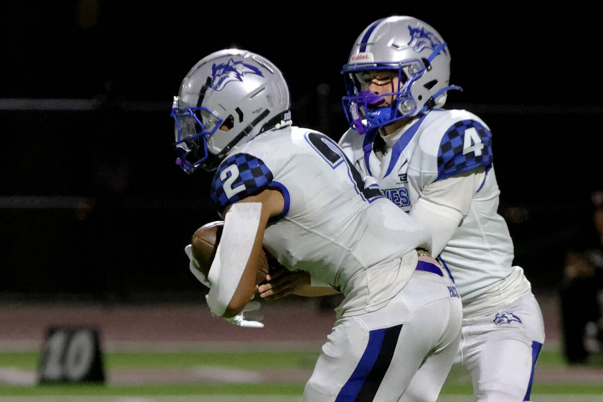 Basic quarterback Andrew Rodriguez (4) hands off to running back Lynn Saltmarch (2) during a hi ...