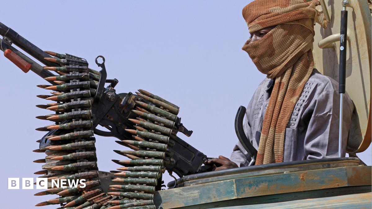 File photo of a defector from the RSF standing in an armed vehicle with a mounted gun and a chain of bullets.