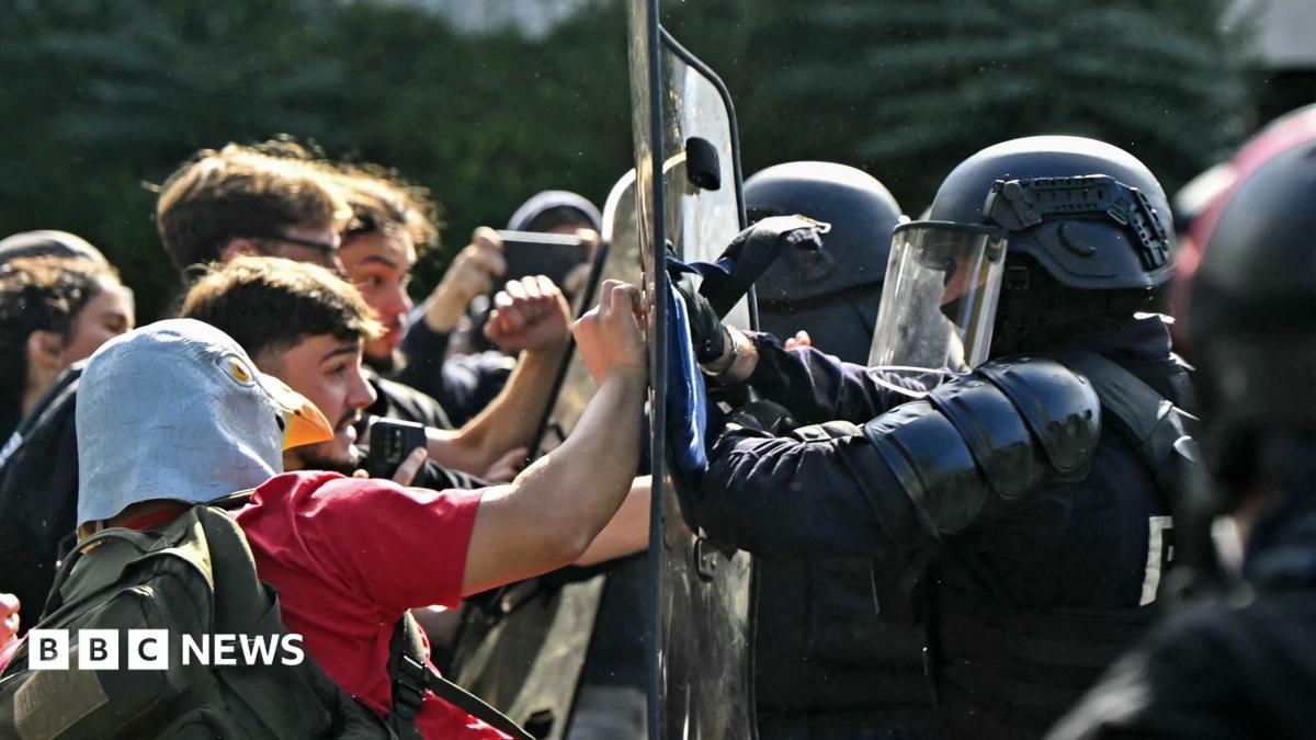 Protesters hold placards behind a barricade to block in Paris, 7 October