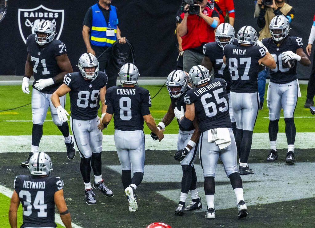Raiders quarterback Kirk Cousins (8) helps to celebrate touchdown catch by tight end Ian Thomas ...