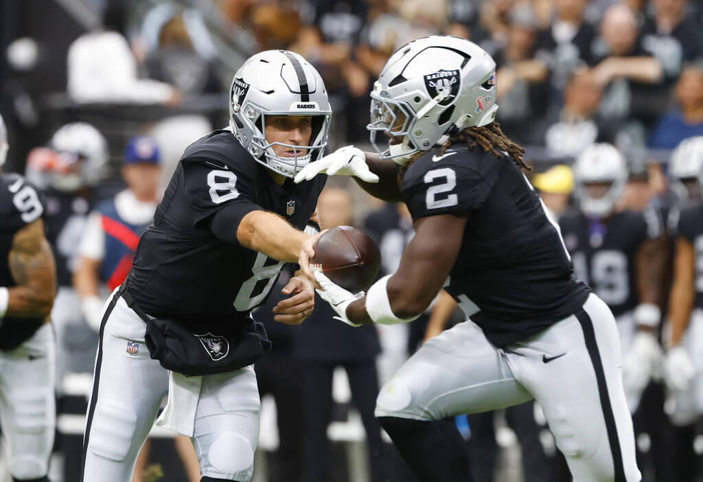Raiders quarterback Kirk Cousins (8) hands off to running back Ashton Jeanty (2) during the sec ...