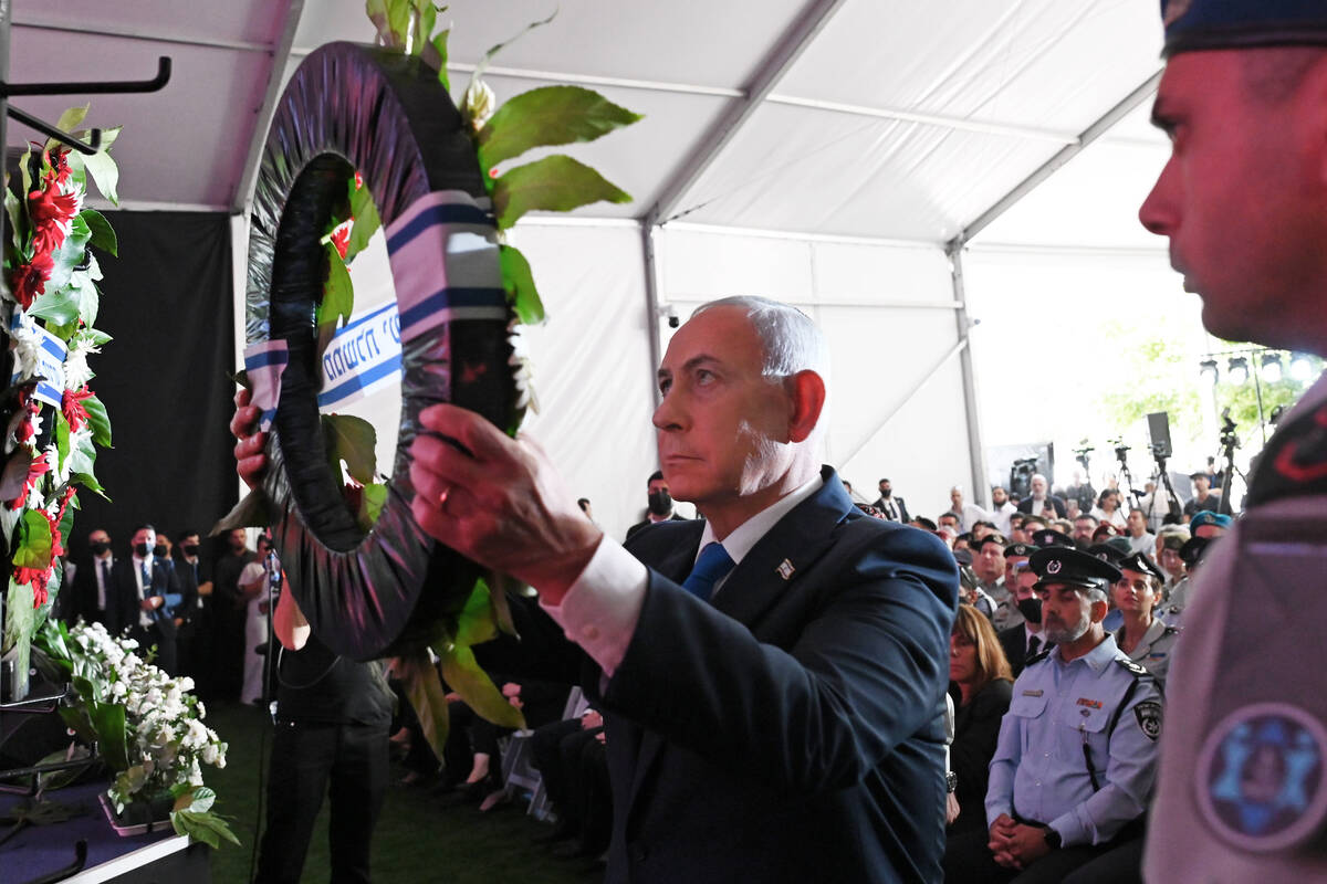 Israel's Prime Minister Benjamin Netanyahu, center, lays a wreath during a state memorial ...