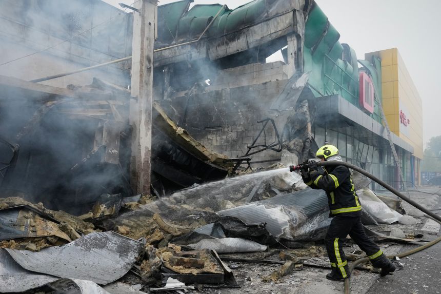 Firefighters try to extinguish a fire after a Russian missile attack in central Kyiv, Ukraine, on Thursday.