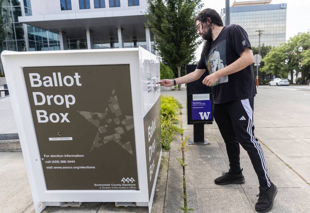 Ben Karpelman pushes his ballot into a ballot drop box on the Snohomish County Campus on Monday, Aug. 4, 2025 in Everett, Washington. (Olivia Vanni / The Herald)