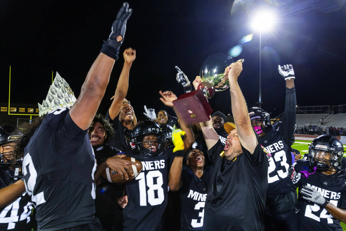 Sunrise Mountain head coach Patrick Achord and his players celebrate their trophy after defeati ...