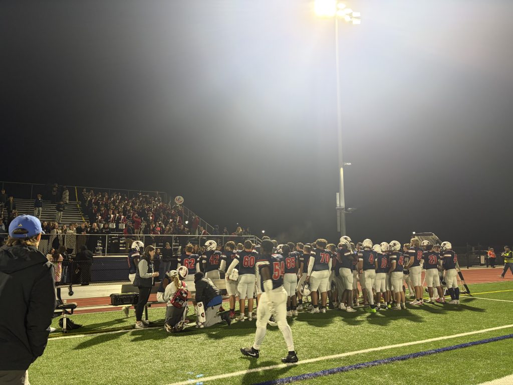 The Newark Charter Patriots gather in front of their fans to celebrate their win over Seaford, Friday night. Photo Credit: Ryan Colasanti