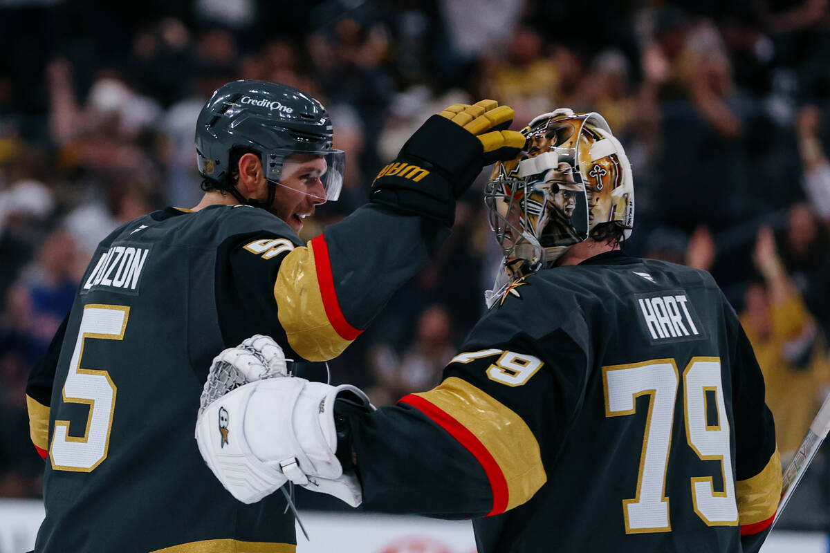 Golden Knights defenseman Jeremy Lauzon (5) embraces Golden Knights goaltender Carter Hart (79) ...